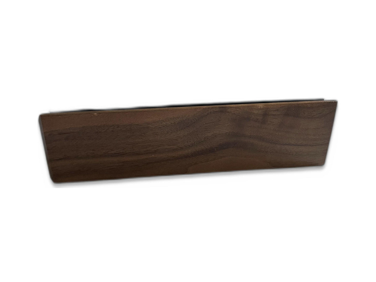 A rectangular wooden block with a dark brown finish and visible natural wood grain patterns. The object has a smooth, flat front surface and angled side edges, presenting a solid, elongated form with a consistent, rich brown tone throughout.