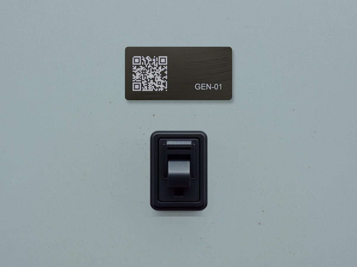 A rectangular black plaque featuring a white QR code on the left and the text GEN-01 on the right, positioned above a black toggle light switch. The components are mounted on a smooth, light gray surface with a matte finish.