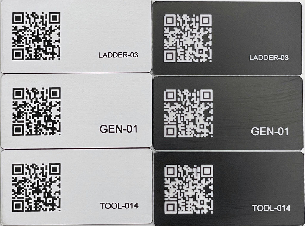 A set of six rectangular engraved identification tags arranged in two columns. Three tags are white with black QR codes and text, and three are black with white QR codes and text. The labels read LADDER-03, GEN-01, and TOOL-014.