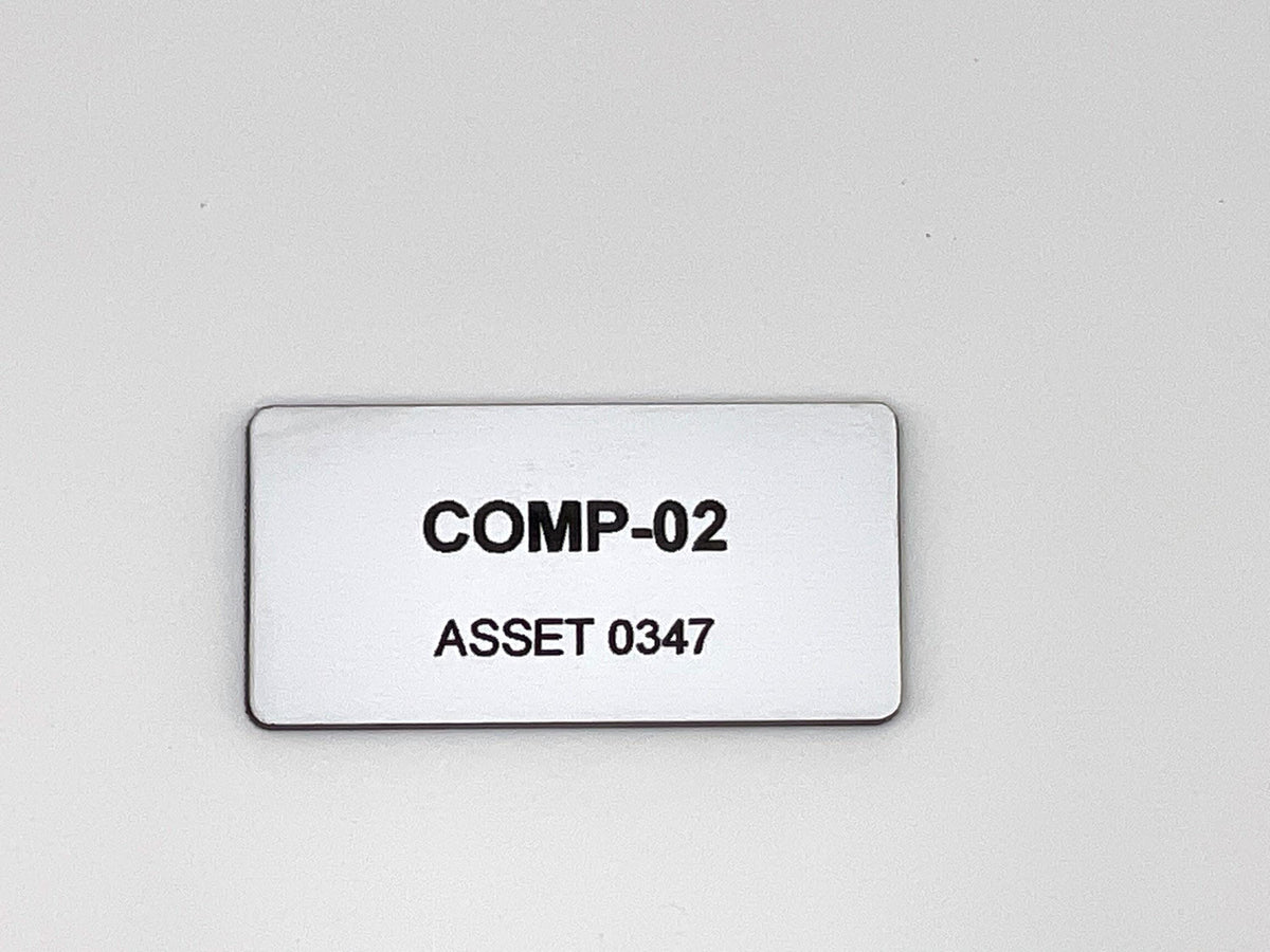 A rectangular white engraved identification tag with rounded corners. The text COMP-02 is engraved in bold black capital letters on the top line, and ASSET 0347 in black capital letters on the bottom line.