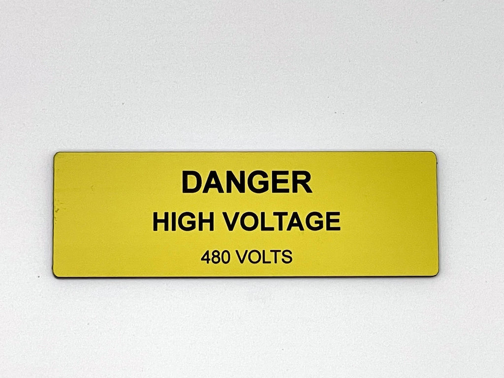 A rectangular yellow safety sign with black text that reads DANGER HIGH VOLTAGE 480 VOLTS. The sign features a bold, clear font and a smooth, flat surface, designed to provide a high-visibility warning for electrical hazards.