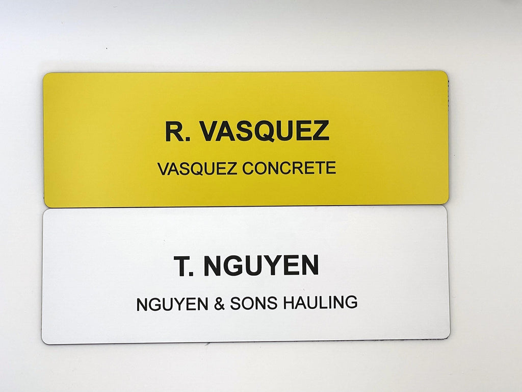 Two rectangular name badges. The top badge is yellow with black text reading R. VASQUEZ and VASQUEZ CONCRETE. The bottom badge is white with black text reading T. NGUYEN and NGUYEN & SONS HAULING. Both badges have rounded corners.