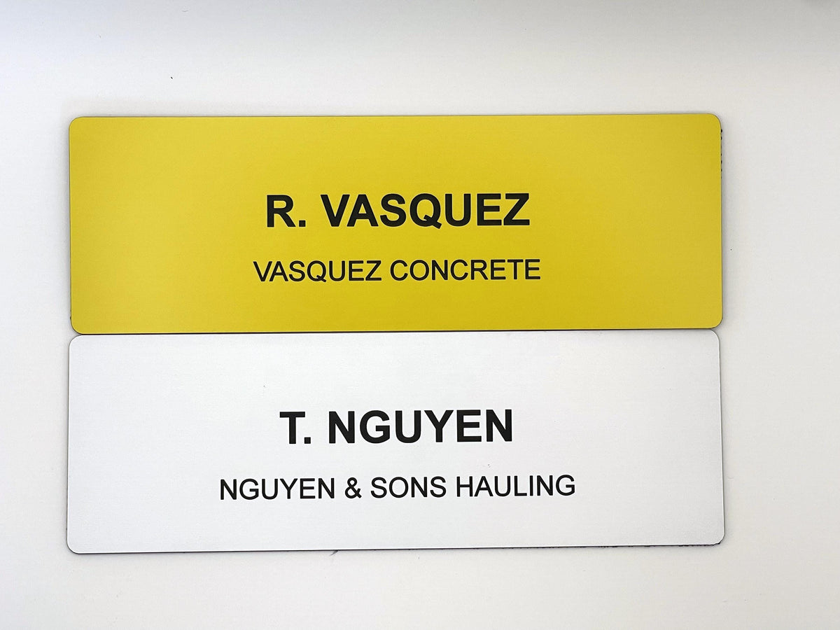 Two rectangular name badges. The top badge is yellow with black text reading R. VASQUEZ and VASQUEZ CONCRETE. The bottom badge is white with black text reading T. NGUYEN and NGUYEN & SONS HAULING. Both badges have rounded corners.