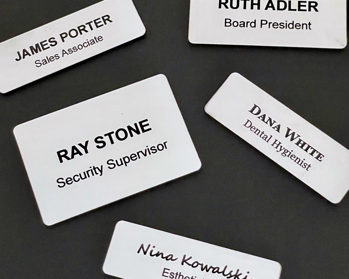 Four rectangular white name badges with black text. The badges display the names James Porter, Ruth Adler, Ray Stone, and Dana White, along with their respective job titles: Sales Associate, Board President, Security Supervisor, and Dental Hygienist.