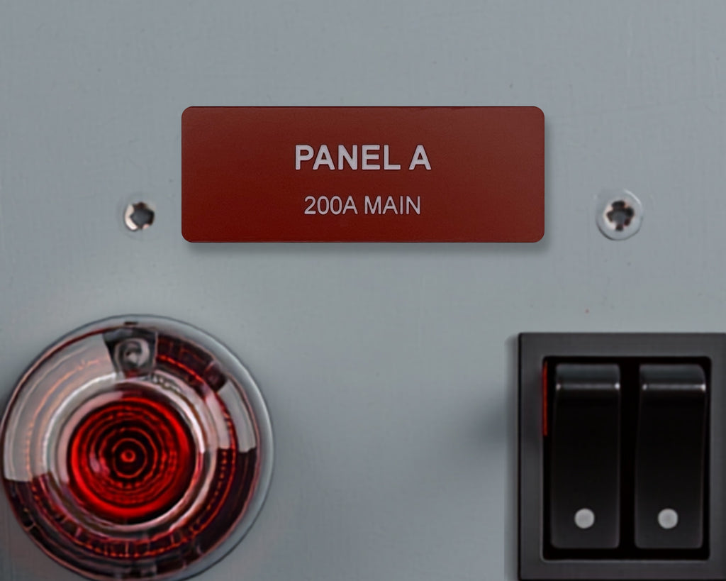 A rectangular dark red identification label with white text reading PANEL A and 200A MAIN, mounted on a light gray surface between two silver screws, positioned above a circular red indicator light and a black dual rocker switch.