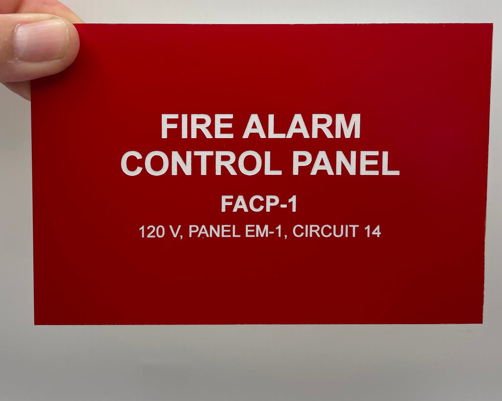 Red engraved plate held in hand, reading FIRE ALARM CONTROL PANEL, FACP-1.