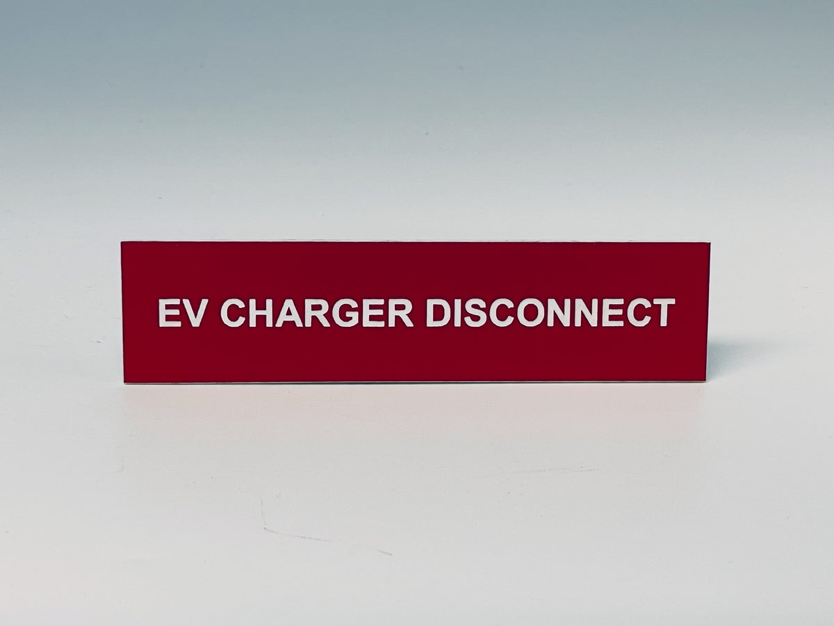 Red engraved label with white letters reading EV CHARGER DISCONNECT.