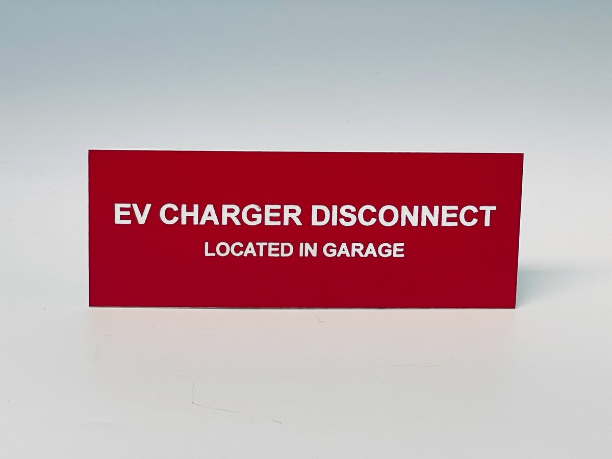 Red engraved label with white letters reading EV CHARGER DISCONNECT, LOCATED IN GARAGE.