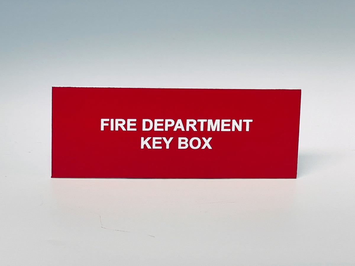 Red engraved placard with white letters reading FIRE DEPARTMENT KEY BOX.
