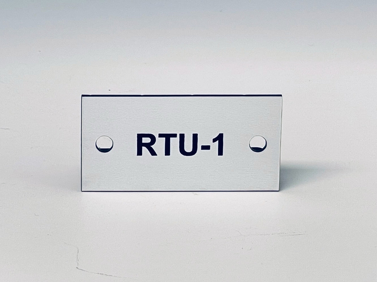 White engraved tag with two screw holes, black letters reading RTU-1.