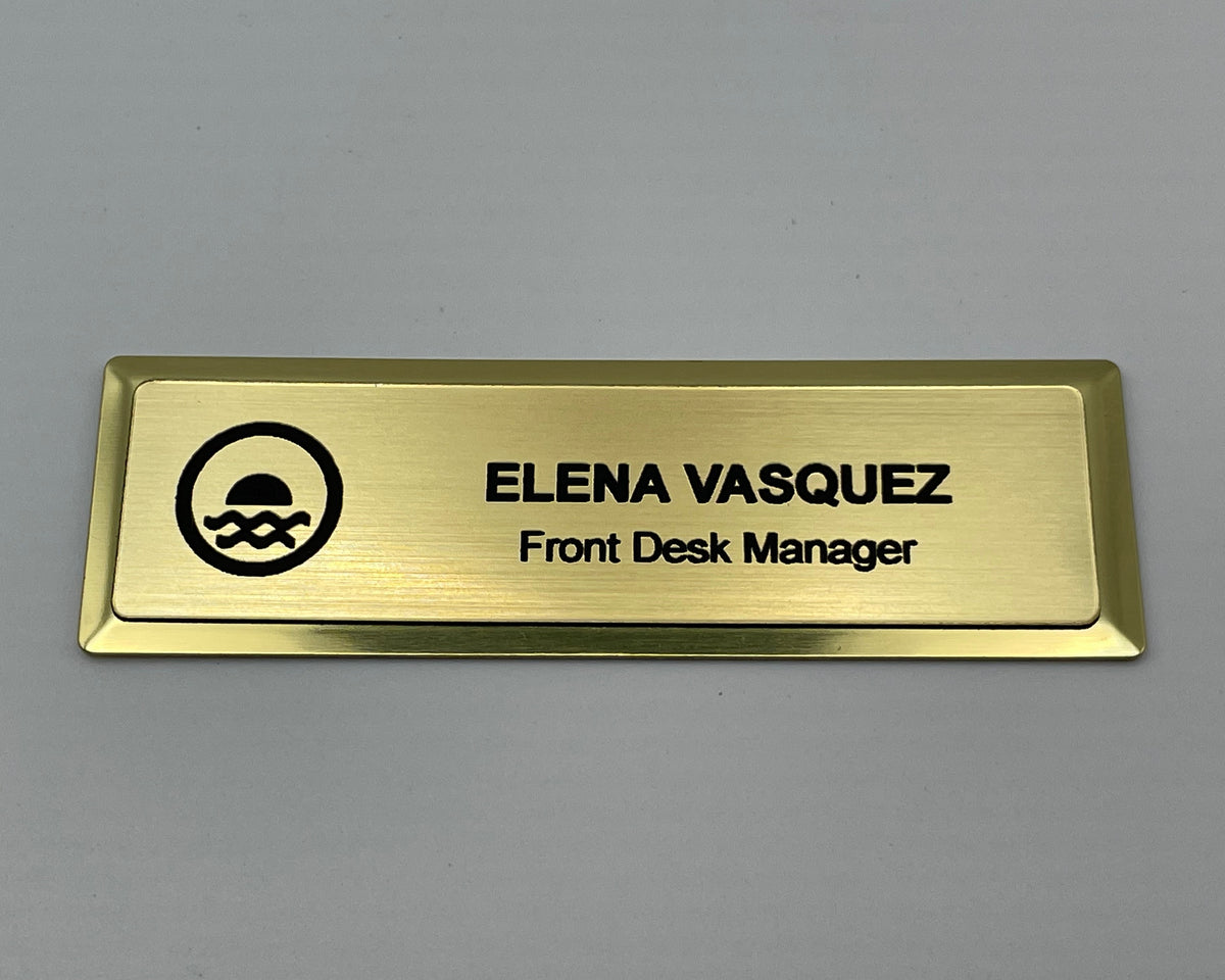 Gold metal bar name badge with an engraved logo, ELENA VASQUEZ, Front Desk Manager.
