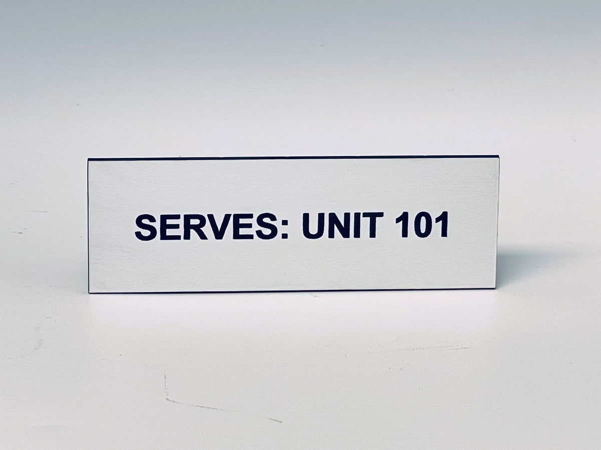 White engraved tag with two screw holes, black letters reading SERVES: UNIT 101.