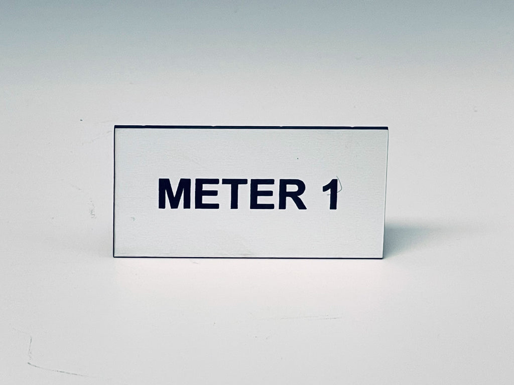 White engraved tag with two screw holes, black letters reading METER 1.