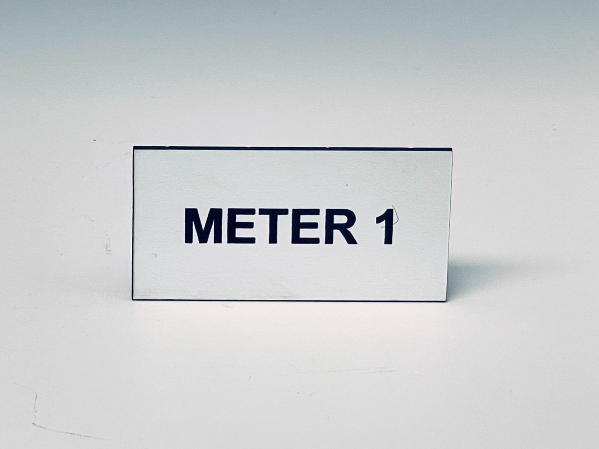 White engraved tag with two screw holes, black letters reading METER 1.