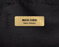 A rectangular gold-toned name badge with a brushed metal-look finish. The text reads MAYA CHEN in bold black letters, with Salon Director engraved below.
