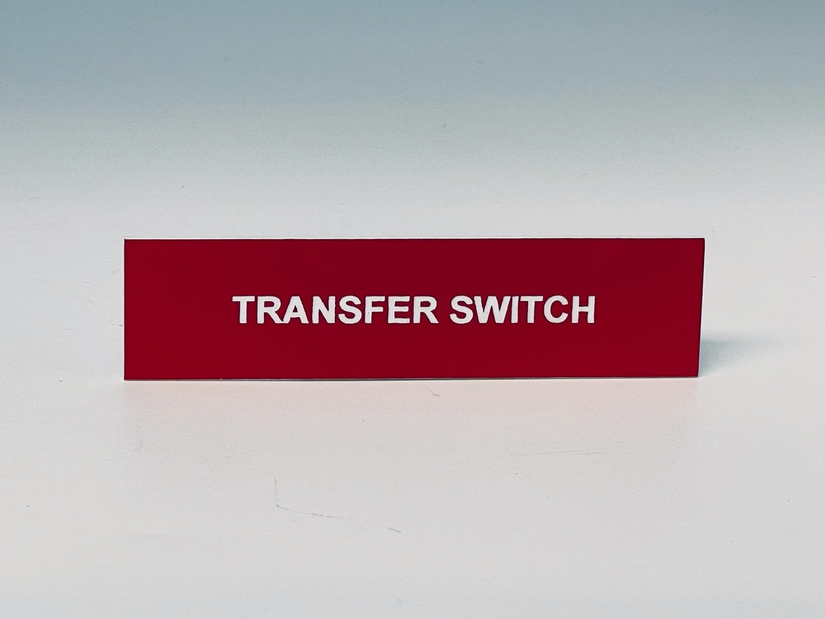 Red engraved label with white letters reading TRANSFER SWITCH.